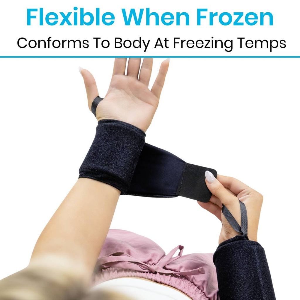 Hand wearing a black wrist support with text 'Flexible When Frozen' and 'Conforms To Body At Freezing Temps'.